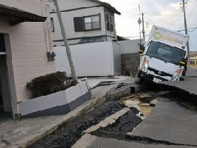 陥没した道路で動けなくなったトラックの画像