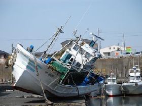 陸に打ち上げられた漁船の画像