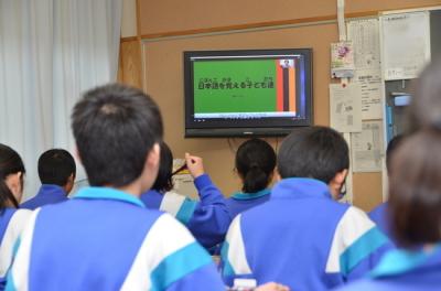 動画を見ながら給食を食べる生徒