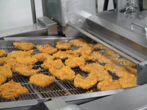 コンベアの上を揚げ物が通る様子