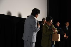 落花生を中村雅俊監督に渡そうとしている